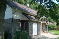 Massivhaus in Gronau (Heek, Ahaus, NRW), Erker mit Schleppdach, Terrassenüberdachung mit Dachabschleppung