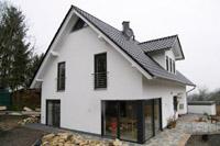 Bauen am Hang in Altenberge, Putzfassade, massiv, farbige Fenster, Fenster über Eck, Gaube, Schornstein für Kamin / Ofen