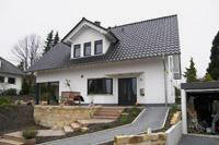 Bauen am Hang in Altenberge, Putzfassade, massiv, farbige Fenster, Fenster über Eck, Gaube, Schornstein für Kamin / Ofen