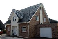 Massivhaus Fertighaus individuell in Lengerich, Westfalen, Eingang überdacht, Lisenen mit Putzstreifen, Erdwärmepumpe