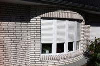 Walmdach Villa Dülmen, Säulen, Tonnendach Gaube, Erker abgerundet, Balkon, weißer Klinker, Garage mit Unterkellerung