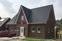 Friesenhaus, Landhausstil, Mauerwerk-Verzierungen, Rundbögen, massive Garage, Klinkerfassade