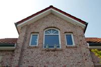 Landhaus Architektur, kleine Dachüberstände, Sandstein Applikationen in der Fassade, 4-Giebel Haus, Sprossen, Rundbögen