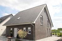 Massivhaus in Münster Hiltrup (Münsterland), Erdwärmepumpe, KfW Effizienzhaus 70, Pultdach Giebel, Klinker, Kamin