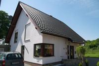 Massivhaus Neubau in Recke, Dreieckgaube, Eckfenster, Wintergarten, sichtbare Pfettenköpfe, Dachschleppe