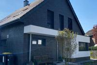 Neubau in Duisburg, modernes Einfamilienhaus mit Satteldach, Erdwärmepumpe, Glattziegel, farbige Dachüberstände, Eckfenster