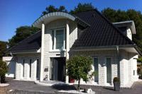 Walmdach Villa Dülmen, Säulen, Tonnendach Gaube, Erker abgerundet, Balkon, weißer Klinker, Garage mit Unterkellerung